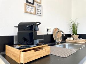 eine Küchentheke mit Kaffeemaschine und Spüle in der Unterkunft AhrPart Hotel Central in Bad Neuenahr-Ahrweiler