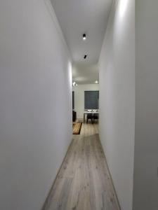 - un couloir avec des murs blancs et une table dans une chambre dans l'établissement Суточная аренда в городе Атырау, à Atyraū