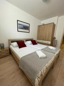 a bedroom with two beds with red pillows at Apartment Sotlar in Izola +27 photos