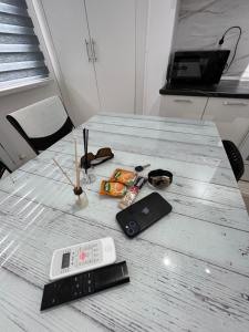 une table munie d'une télécommande et d'autres éléments. dans l'établissement Суточная аренда в городе Атырау, à Atyraū