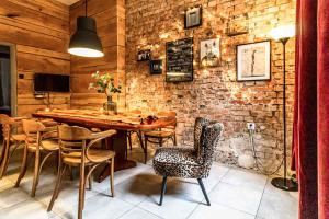 comedor con pared de ladrillo, mesa y sillas en Old Town Centrum Residence Apartments, en Poznan