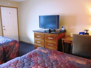 a bedroom with a bed and a television at Lakeshore Inn & Suites in Anchorage