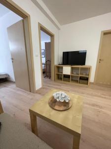 a living room with a table and a tv at Apartment Sotlar in Izola