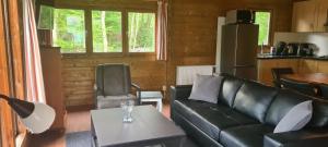 uma sala de estar com um sofá e uma mesa em Vakantiepark 't Urkerbos - 5 persoons Brabantse blokhut em Urk