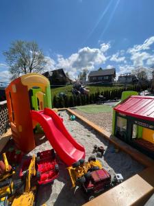 een kinderspeelplaats met een glijbaan en speelgoedauto's bij Baranek in Czerwienne