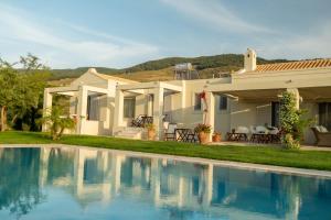 a house with a swimming pool in front of a house at Kos Secret Villa with private pool in (( Kermetés ))