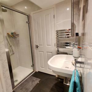 a white bathroom with a shower and a sink at 1 bed flat near Little Venice and Paddington in London