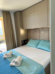 ein Schlafzimmer mit einem Bett mit zwei Handtüchern darauf in der Unterkunft Mobile House Hana E8 in Lučica