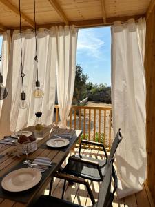 einen Holztisch und Stühle auf einer Terrasse mit einem Fenster in der Unterkunft Mobile House Hana E8 in Lučica