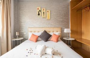 1 dormitorio con 1 cama blanca grande con almohadas en Appartement 26 ensoleillé à 5 min de la plage El Jadida, en El Jadida