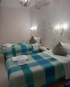 duas camas num quarto de hotel com toalhas em Mini alloggio rosmarino vicino alla porta Elisa em Lucca