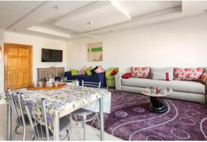 a living room with a table and a couch at Appartement 26 ensoleillé à 5 min de la plage El Jadida in El Jadida