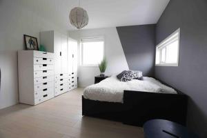 a bedroom with a bed and a white dresser at Sjønært hus på idylliske Husøy in Tønsberg