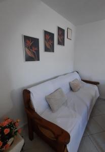 un sofá blanco en una habitación con fotos en la pared en Cyclops apartment, en Serifos Chora