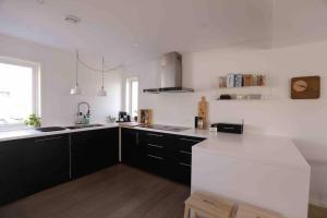 a kitchen with black cabinets and a white counter top at Sjønært hus på idylliske Husøy in Tønsberg