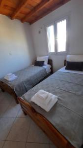 dwa łóżka w pokoju z dwoma oknami w obiekcie Cyclops apartment w mieście Serifos Chora