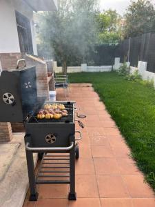 a barbecue grill with food cooking on a patio at Chalet PuigVal 50m de la playa in Valencia