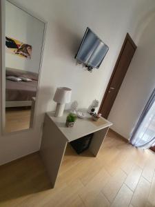 a room with a table with a tv and a mirror at La casa di Serafina in Santo Stefano di Camastra