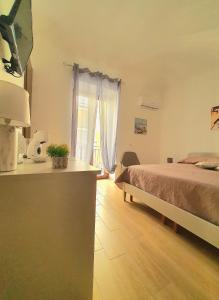 a bedroom with a bed and a desk and a window at La casa di Serafina in Santo Stefano di Camastra