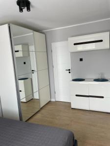 a bedroom with white cabinets and a mirror at Apartament Zeromskiego in Ostróda