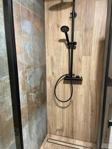 a shower with a shower head in a bathroom at Apartament Zeromskiego in Ostróda