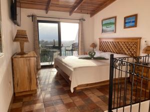 1 dormitorio con 1 cama y balcón en Hotel Los Cielos Del Caribe, en Cahuita