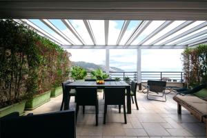 een patio met een tafel en stoelen en een groot raam bij Taormina Romantic Apartment by Taormina Holidays in Taormina