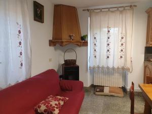 sala de estar con sofá rojo y ventana en ANAMAR, en Lugo