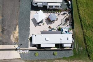 an aerial view of a white trailer with tables and umbrellas at iconic rv with pool/ terrace in Arecibo