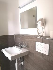 ein Bad mit einem Waschbecken und einem Spiegel in der Unterkunft Aparthotel Résidence Bernerhof in Wengen