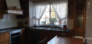 cocina con fregadero y ventana en ANAMAR, en Lugo