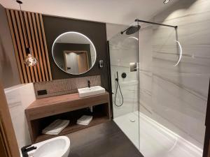 a bathroom with a shower and a sink and a mirror at Residence Tantalus in San Lorenzo di Sebato