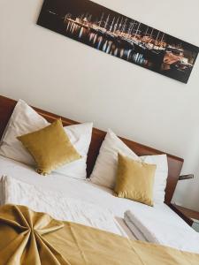 ein Bett mit weißer Bettwäsche und goldenen Kissen in der Unterkunft VILLA M&M - sea and beach within 35 steps in Zaboric
