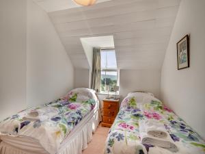 two beds in a room with a window at Gunpowder House in Mickleby