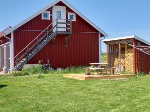 a red barn with a picnic table in front of it at Lägenhet på landet in Torsby