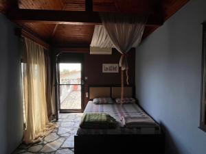 a bedroom with a bed in a room with a window at Thomis House in Nea Iraklia