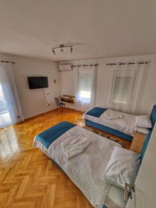 a room with two beds and a television in it at Apartman Cvetkovic in Vranje