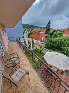 balcone con tavolo, sedie e ombrellone di Apartman Cvetkovic a Vranje