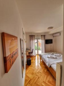 a bedroom with a large bed and a desk at Apartman Cvetkovic in Vranje