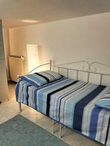 ein Schlafzimmer mit einem Bett mit einer gestreiften Decke in der Unterkunft Domu Mia in Cattolica