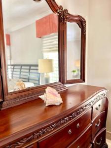 Una cómoda de madera con un espejo encima. en King Bedroom Suite at ParadiseOneVilla Turks and Caicos Islands, en Providenciales