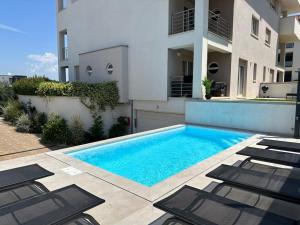 a swimming pool with chairs in front of a building at Volme Resort in Banjole