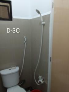 a bathroom with a white toilet and a shower at DCAR Residences - Transient House in Tanza