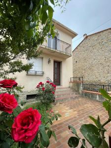 a house with red roses in front of it at LG RITE Appartement avec jardin in Prades