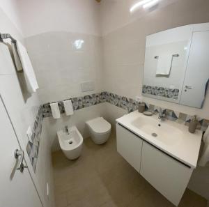 a white bathroom with a toilet and a sink at L'Antico Pozzo in Pozzallo