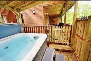 a large hot tub on the deck of a cabin at Rocklands Lodges in Pickering