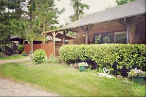 ein Haus mit einem Zaun und einem Hof mit Pflanzen in der Unterkunft Rocklands Lodges in Pickering