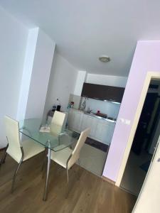 a dining room with a glass table and white chairs at Pomorie Direkt am Pool in Pomorie