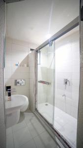 La salle de bains est pourvue d'une douche en verre et d'un lavabo. dans l'établissement Ikeja Airport View, à Lagos