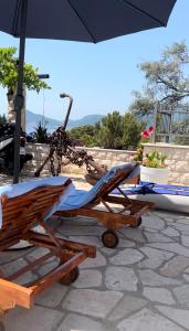 two lounge chairs and an umbrella on a patio at Villa Milan in Sveti Stefan